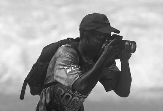 Jorge Gustavo fotografando com teleobjetiva na praia