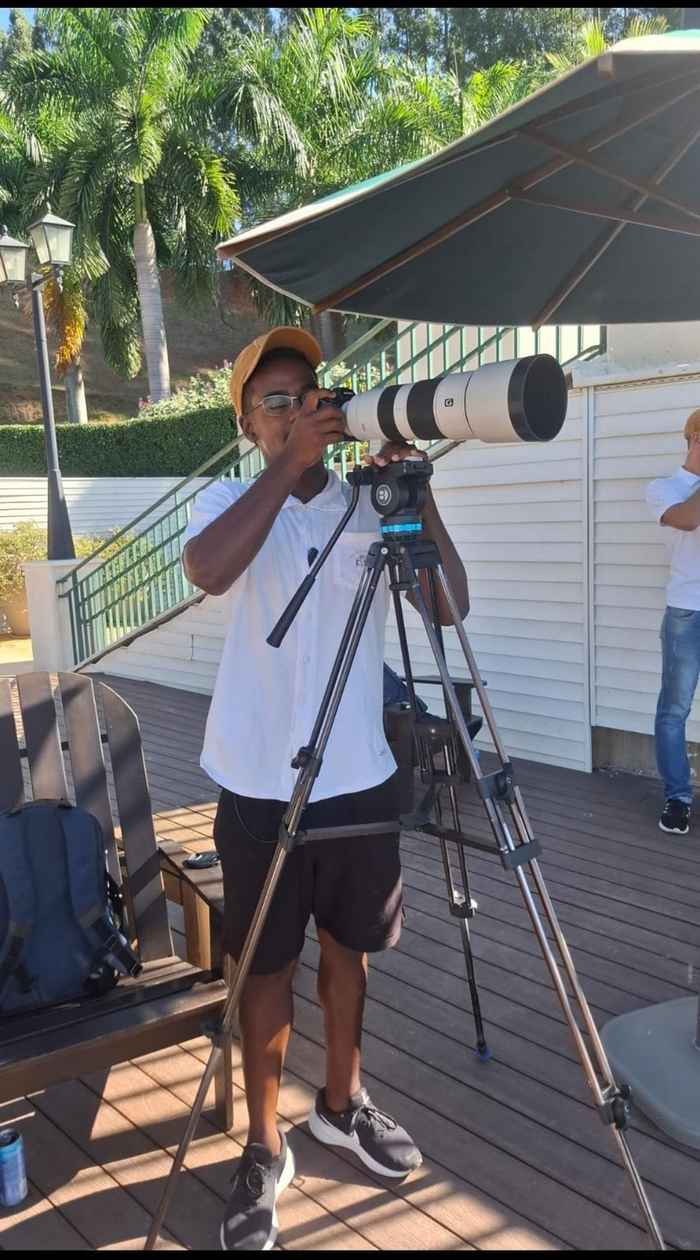 Jorge Gustavo operando câmera profissional com teleobjetiva